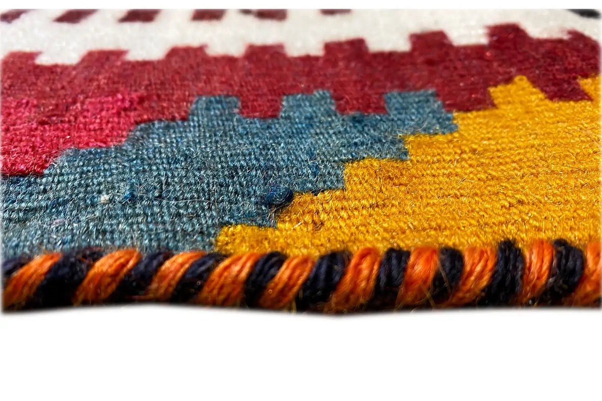 Kilim-Qashqai rug, close-up: multicolored woven texture and black fringes