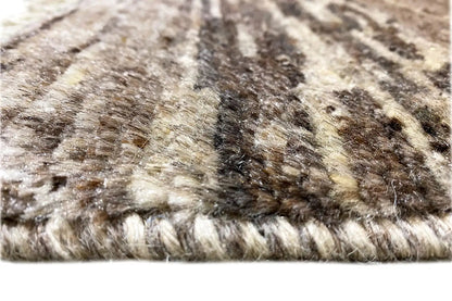 Rug surface with beige and dark brown fibers and fringes along the edge