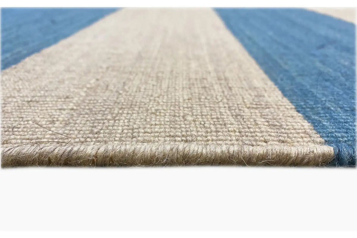 Carpet edge with light beige fringe trim and blue stripe