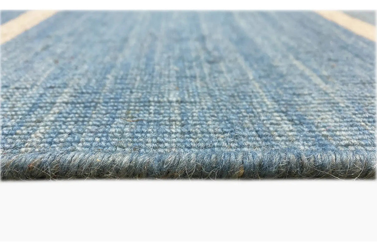 Kilim rug detail: short fringe and woven blue-beige texture
