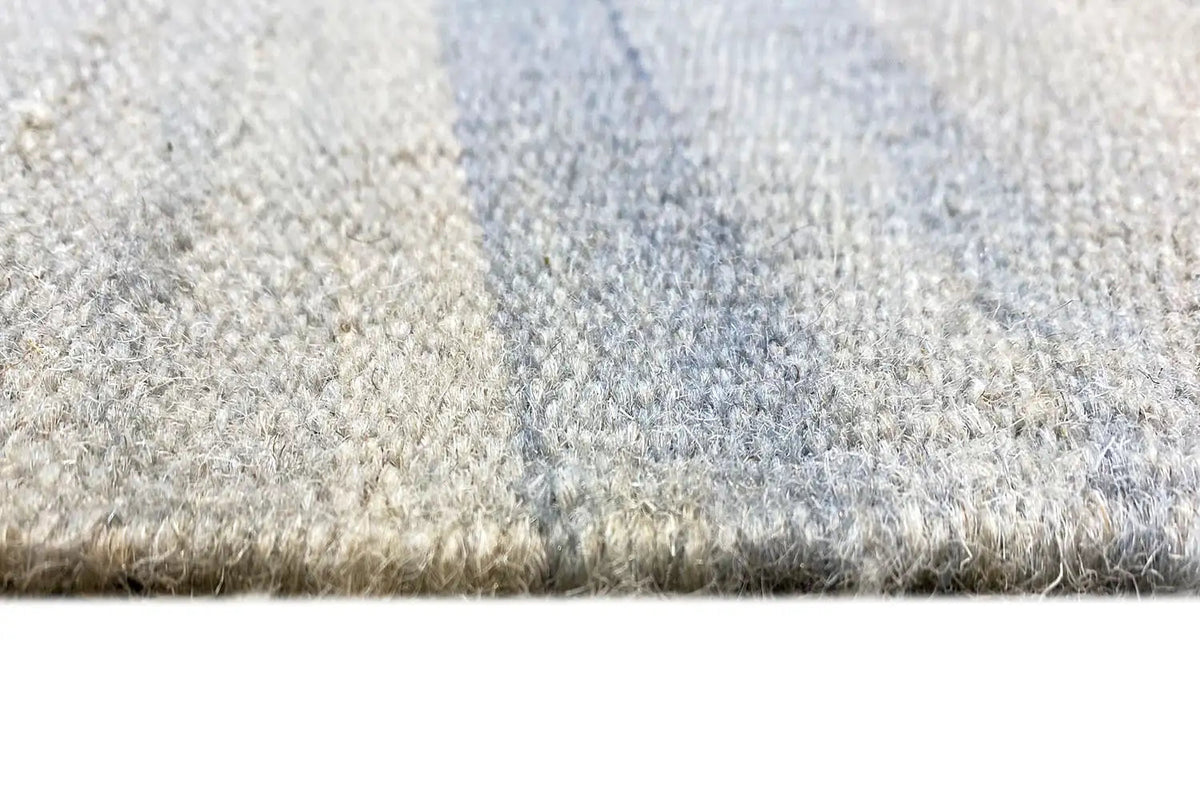 Kelim dhurrie rug close-up: pile and woven edge in light blue/beige