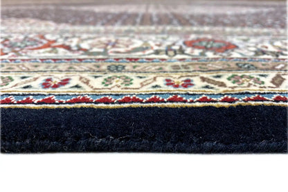 Tabriz-style rug with a border pattern around the edge and a dark pile underside