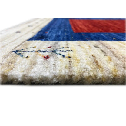 Close-up of a gabbeh rug at the edge: blue-red stripe on a cream-colored background