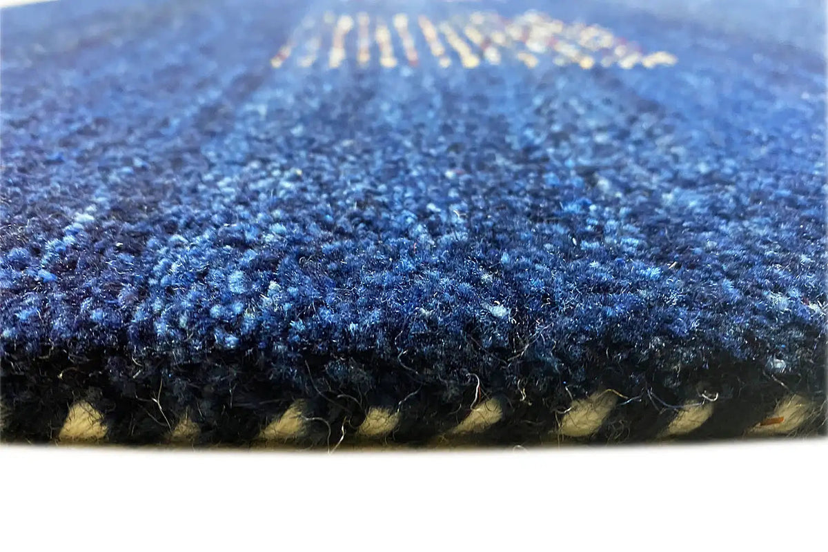 Close-up: blue carpet with a dense pile surface and bound edge