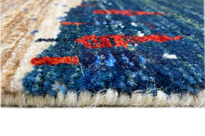 Gabbeh rug detail: fringe along the bottom edge with a blue pattern and red accents