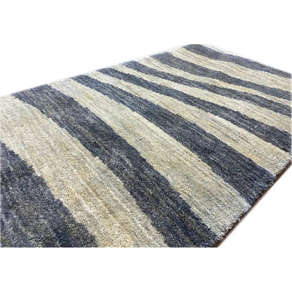 Close-up of a striped rug in blue-gray and beige, detailed low-pile texture
