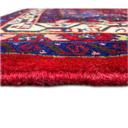 Carpet edge with red pile and a colorful pattern in blue, red, and cream, rectangular section