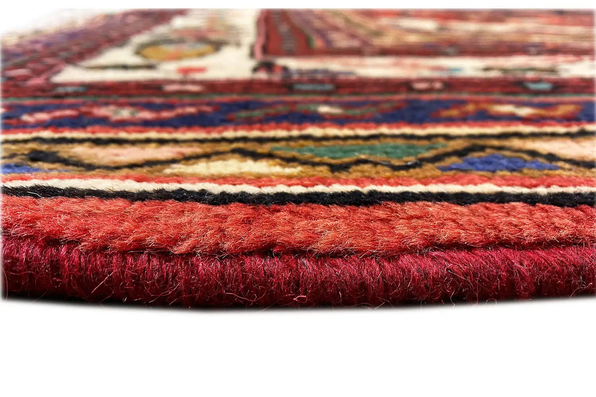 Rug edge with dense pile, red-dyed hem, and multicolored stripes