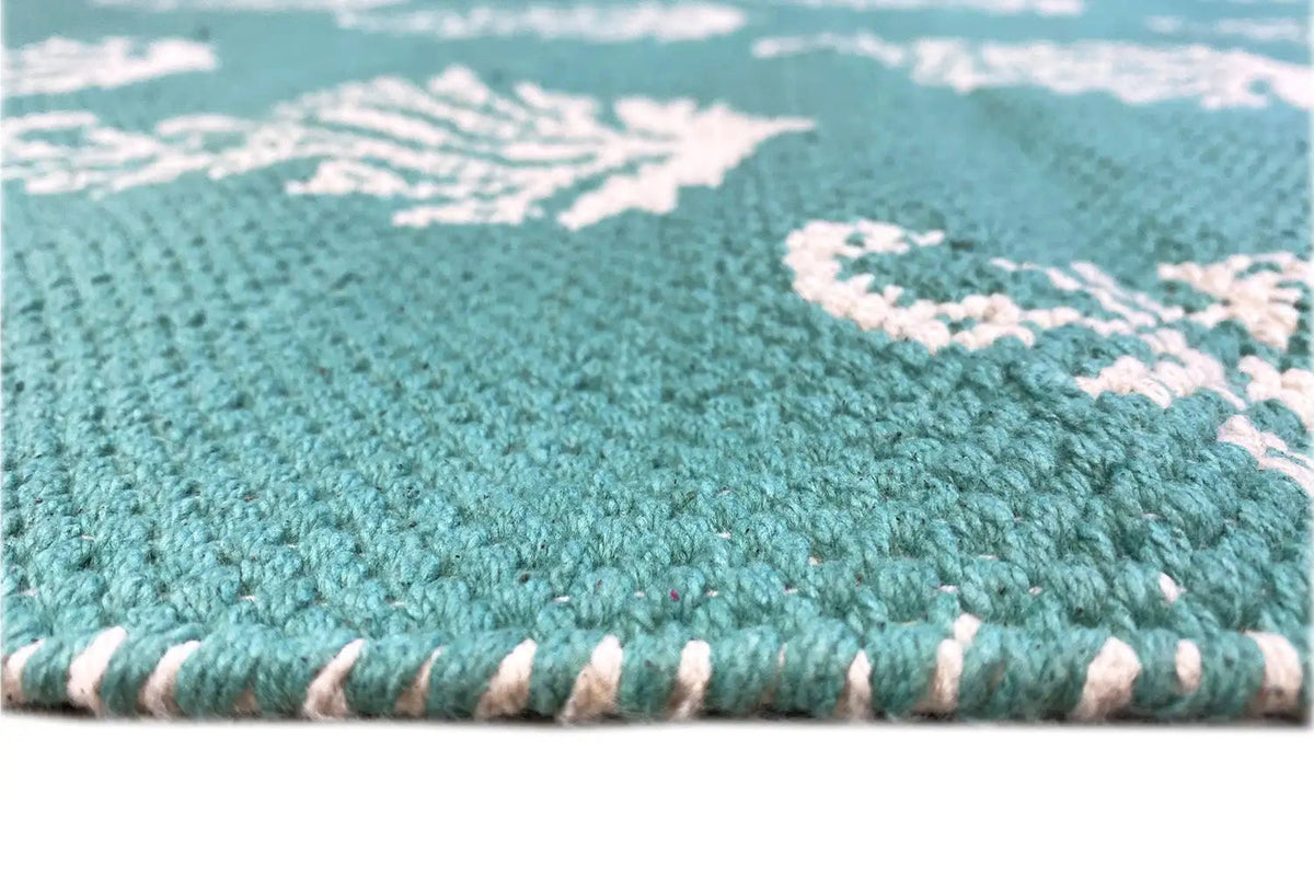 Green rug with a white tree pattern, detail of the edges and selvedge