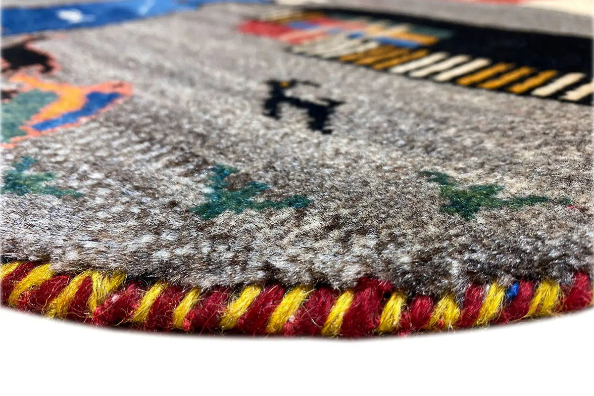 Close-up of the Gabbeh rug: colorful fringes and dense pile along the edge