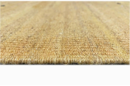 Close-up: ochre-colored kilim textile surface with a fine pile and fringed edge