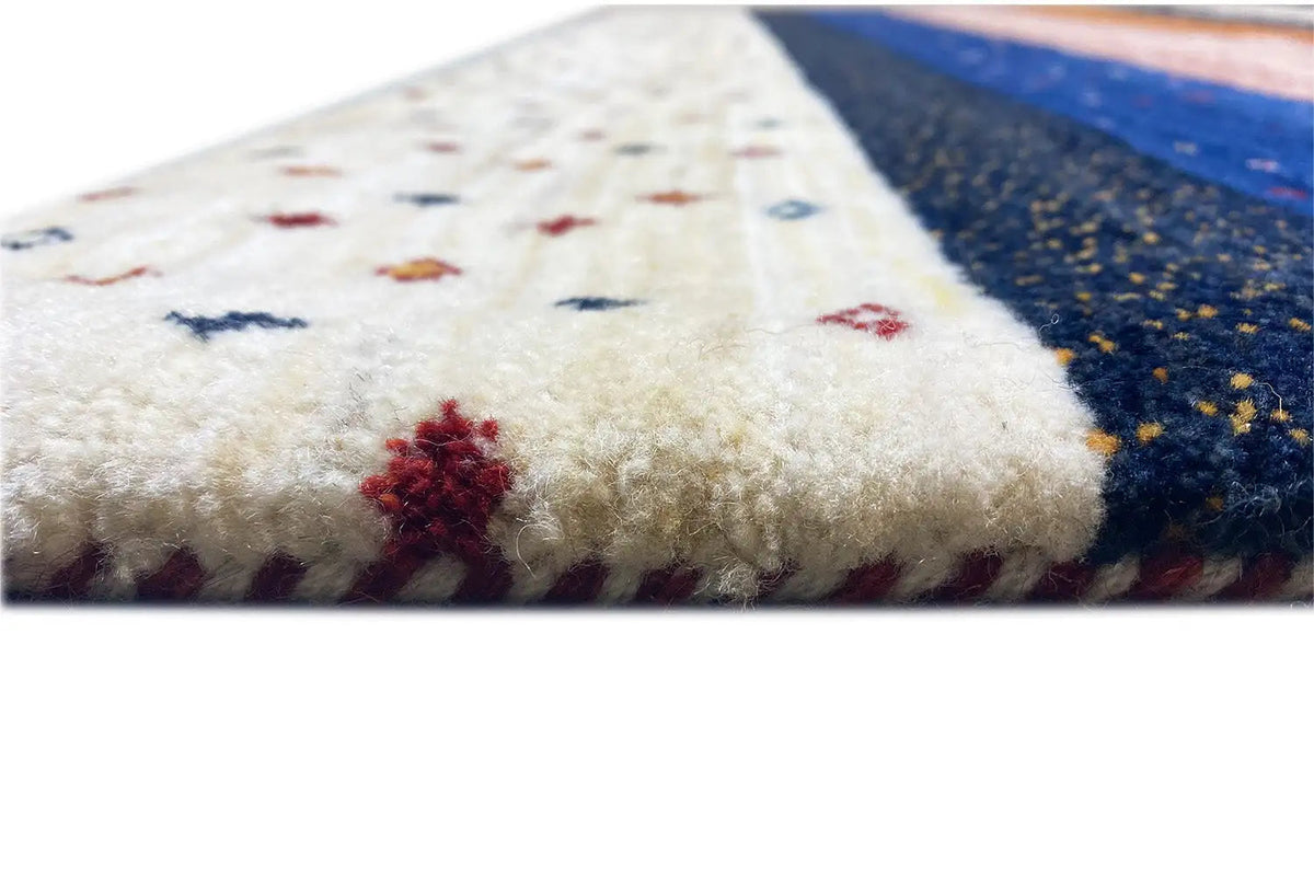 Gabbeh rug pile in detail: soft light wool with red and blue color accents