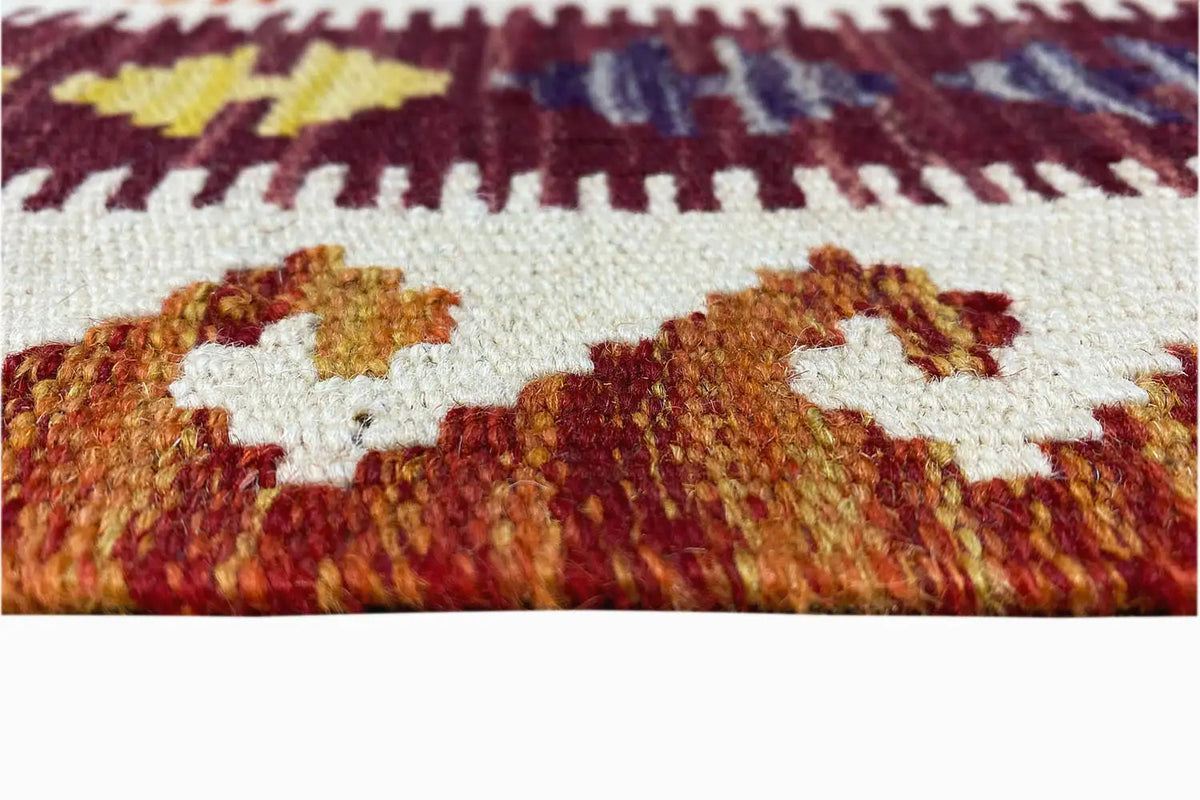 Close-up of a kilim runner: woven surface with colorful motifs and short fringes