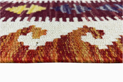 Close-up of a kilim runner: woven surface with colorful motifs and short fringes