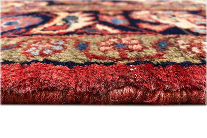 Carpet edge with red pile and visible fringe trim, close-up