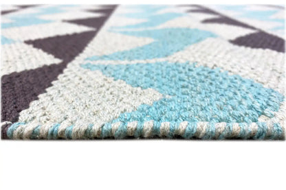 Close-up of a kilim rug: woven surface with a colored edge and short fringes