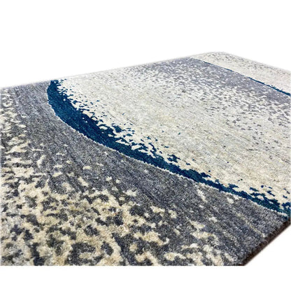 Close-up of Gabbeh rug: light beige texture with dark blue border and gray pattern