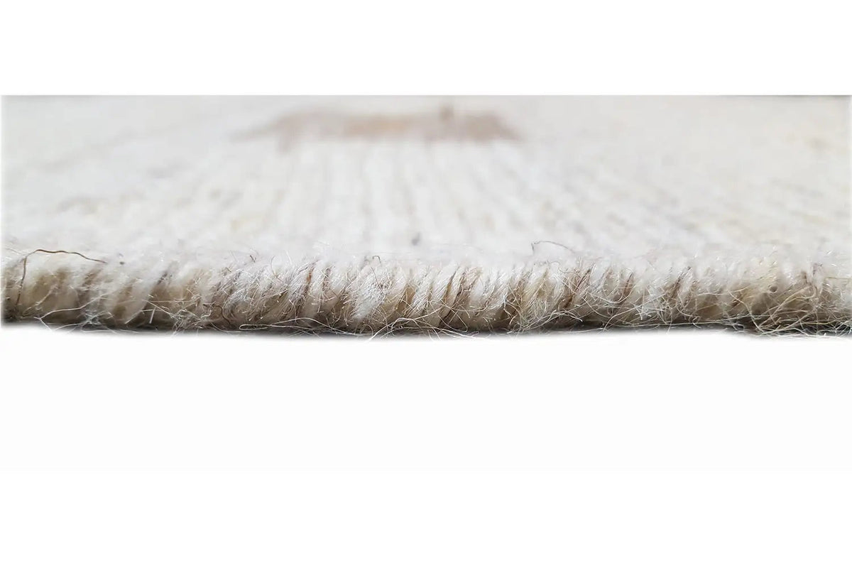 Close-up of the fringed edge of a beige kilim runner, with curly braided yarn visible