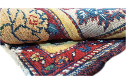 Close-up: woven rug with fringes, blue-red-yellow pattern and offset borders