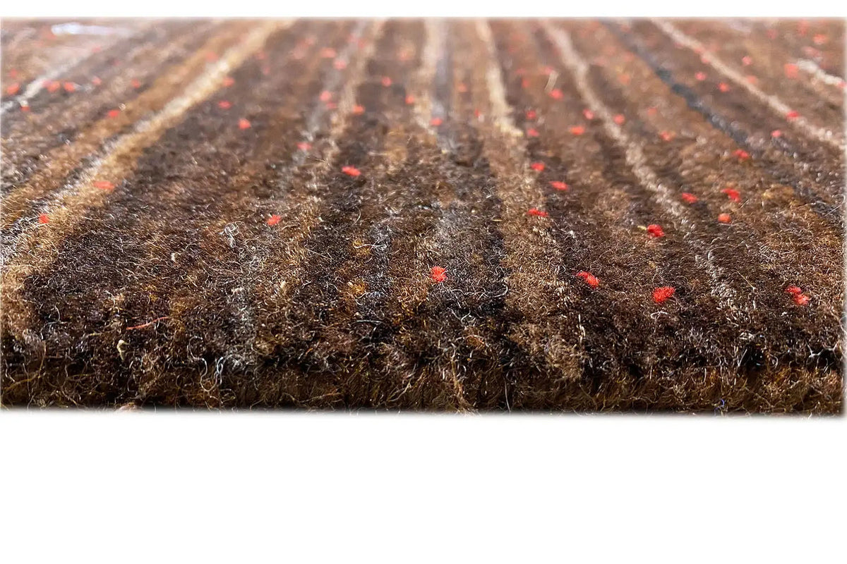 Close-up of the carpet pile: dense brown wool base with fine red flecks