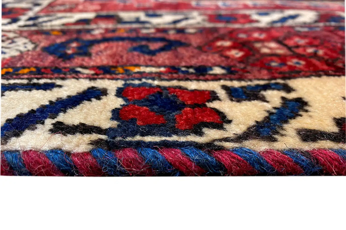 Oriental rug with a red and blue pattern, cream-colored, fringed edges