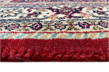 Carpet edge with fringe and dense pile; red-backed border in detail.