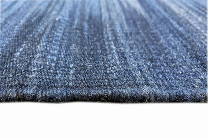 Close-up: blue kilim dhurrie with a dense weave and contrasting edge