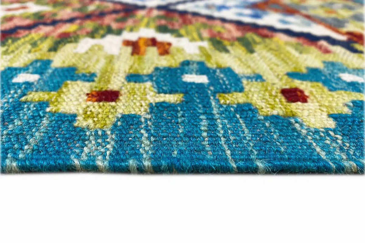Detail of the kilim runner: blue border, colorful embroidered patterns, visible weave texture