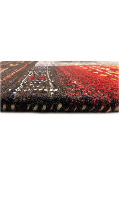 Edge area of the Gabbeh rug with red and dark pile, geometric pattern