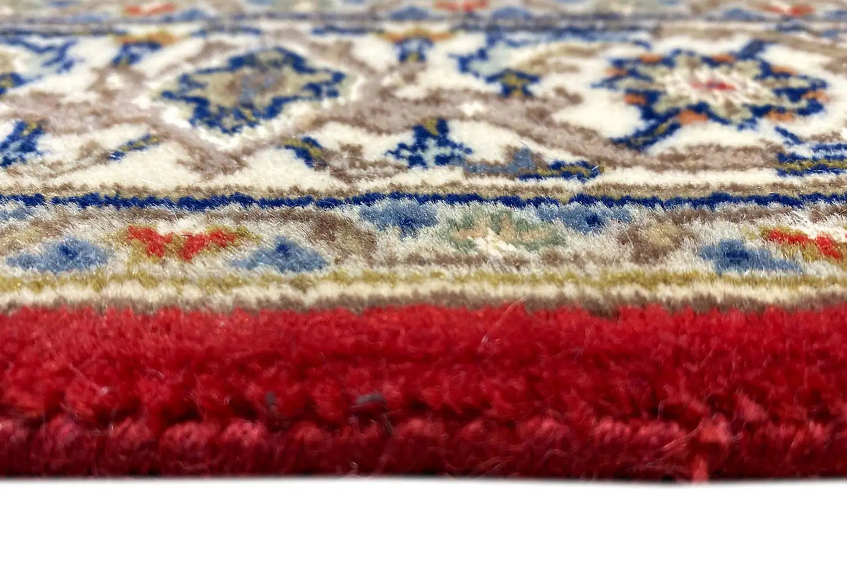 Runner edge in detail: red pile with an ornamental pattern in blue and beige (close-up)