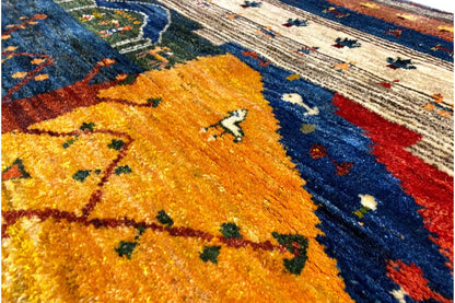 Gabbeh Lori rug close-up: yellow field with small figures and lines