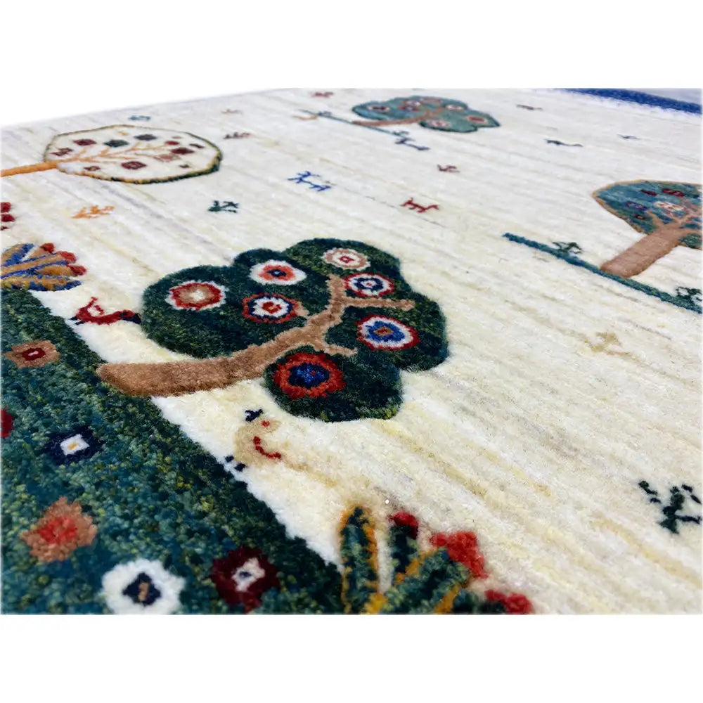 Gabbeh rug detail view: large tree figure, animals, and colorful flowers in a cream pattern