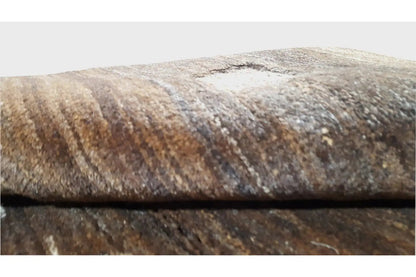Close-up of the Gabbeh rug: textured border area, brown-beige pile