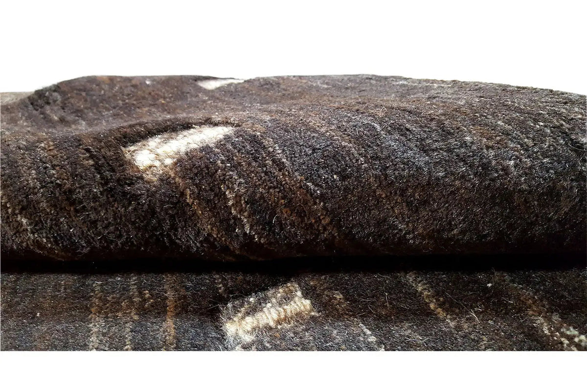 Gabbeh carpet pile detail, dark fibers with beige inclusions on the top surface