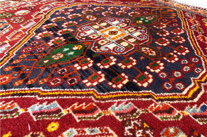Close-up of a carpet with a geometric ornamental pattern in red, black and green