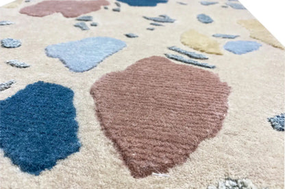 Detail: Carpet with a large pink stain and blue shapes on beige