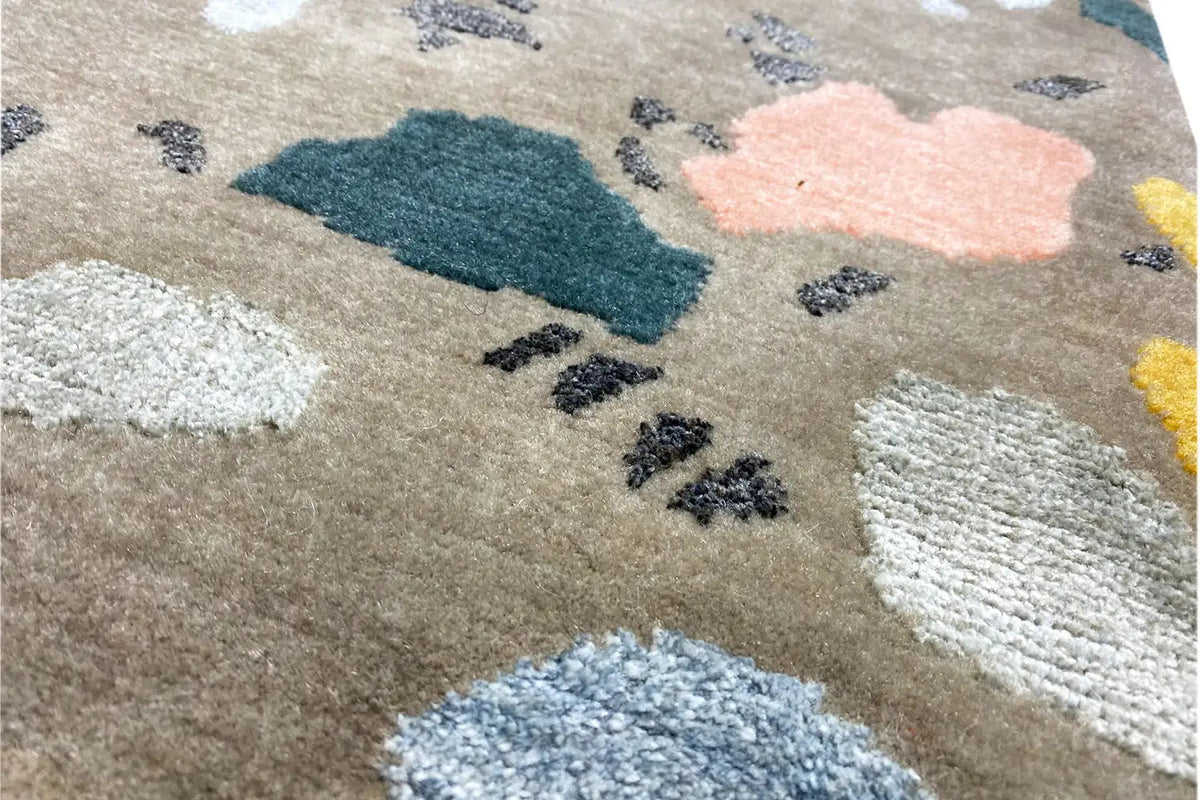 Close-up of the carpet pile: beige base fabric with blue, pink, and white accents