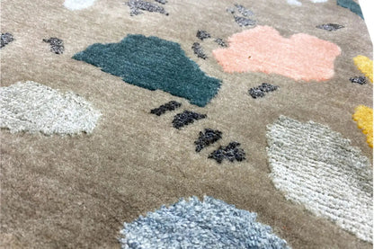 Close-up of the carpet pile: beige base fabric with blue, pink, and white accents