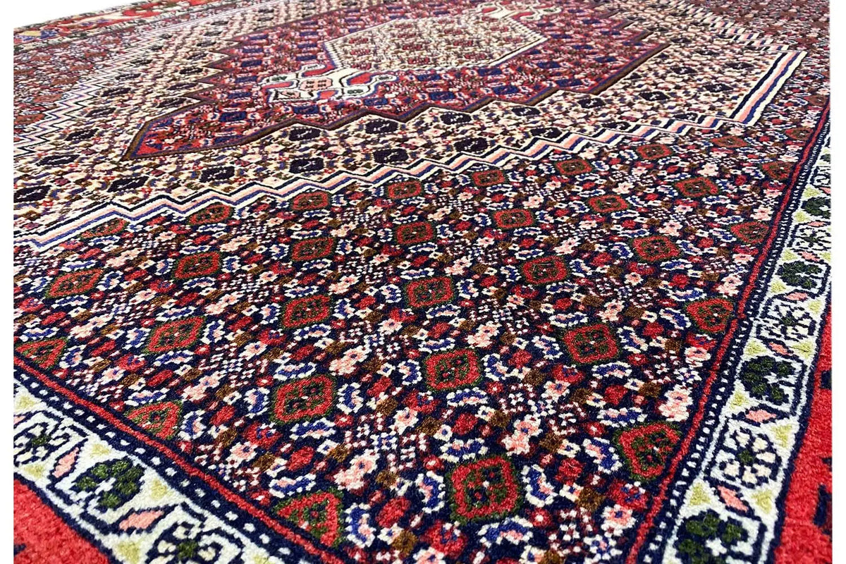Carpet detail view: ornamental pattern of small motifs in dark red, blue, and beige