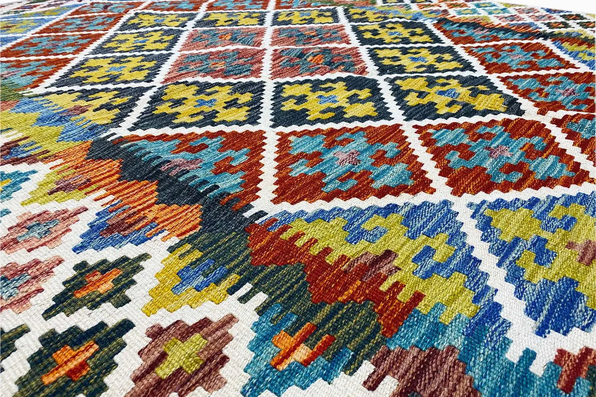 Kilim detail with a dense woven pattern of diamonds, squares, and zigzags in multicolored tones