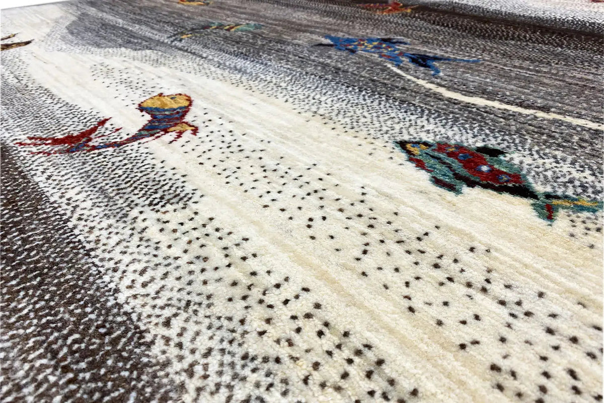 Close-up of a Gabbeh rug: cream-colored stripe with colorful animal motifs