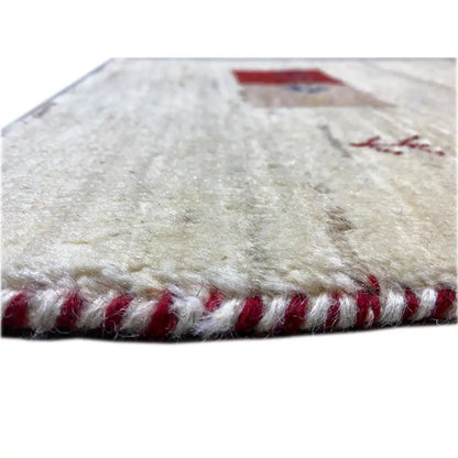 Gabbeh rug with a beige pile and a bound edge with short red fringes