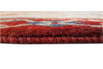 Close-up of a rug edge with dense, reddish pile and fringe trim