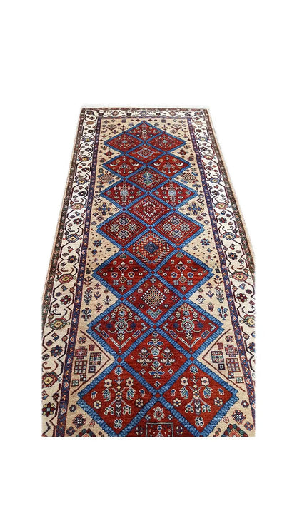 Oriental rug with a vertical diamond pattern, blue and red design on a beige background
