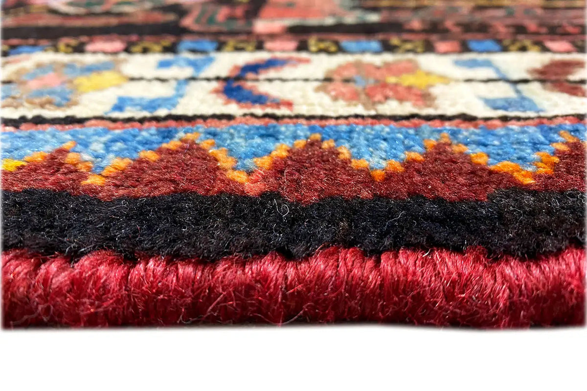Carpet edge with fringe, red and black fiber bundles, visible weave structure