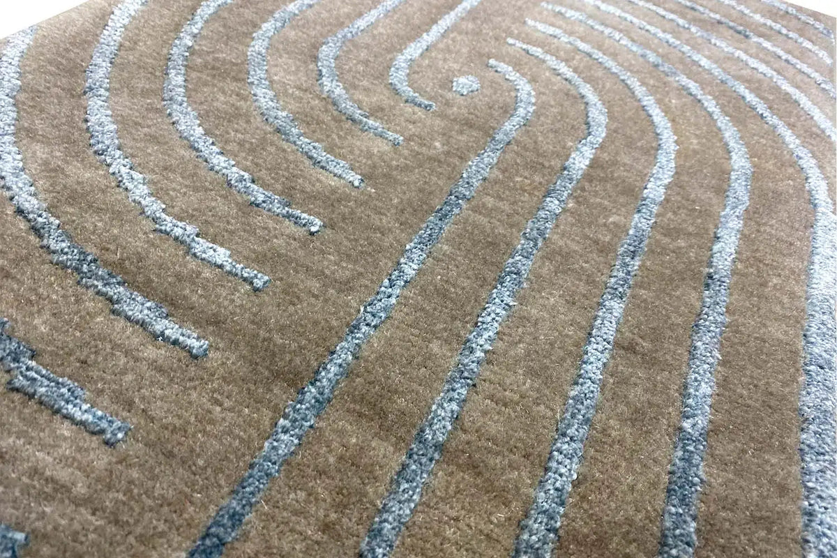 Designer rug with turquoise curved lines in a swirling pattern on a beige background