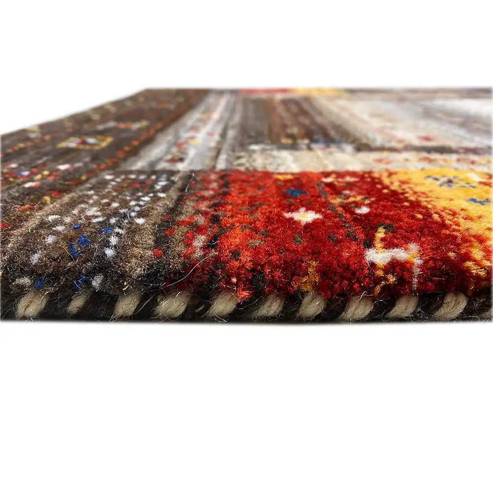 Gabbeh rug edge view with dense pile, red and yellow color patches, patterned