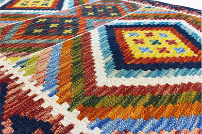 Close-up of a kilim runner: woven diamonds and stripes in orange, blue, green, and yellow