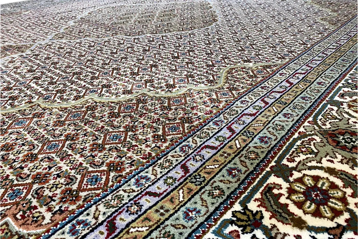 Close-up: dense carpet with a small-scale ornamental pattern in brown, cream, blue, and red