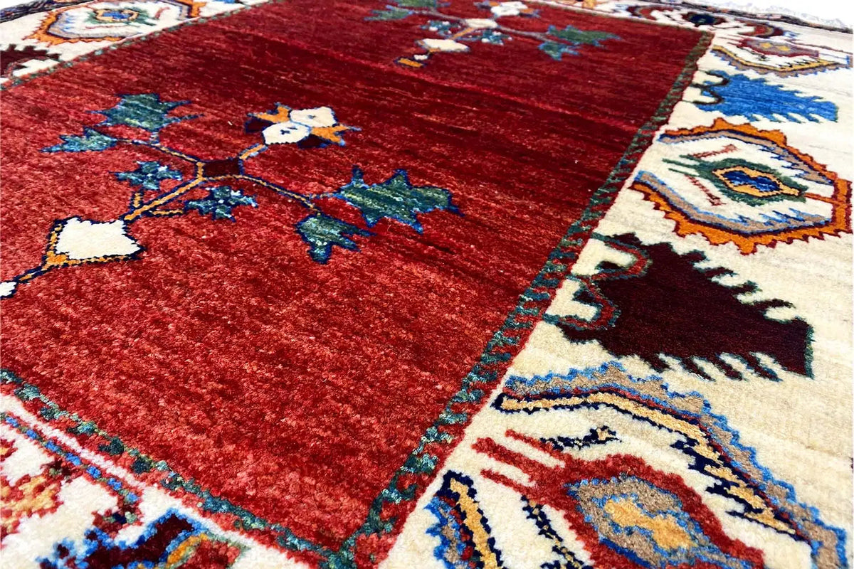 Close-up: red carpet with green and blue ornaments, bordered in bright colors